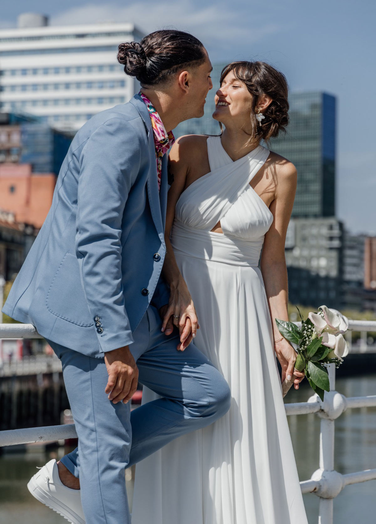 Sesión de fotos de boda en el exterior con la ría y arquitectura moderna de Bilbao de fondo.