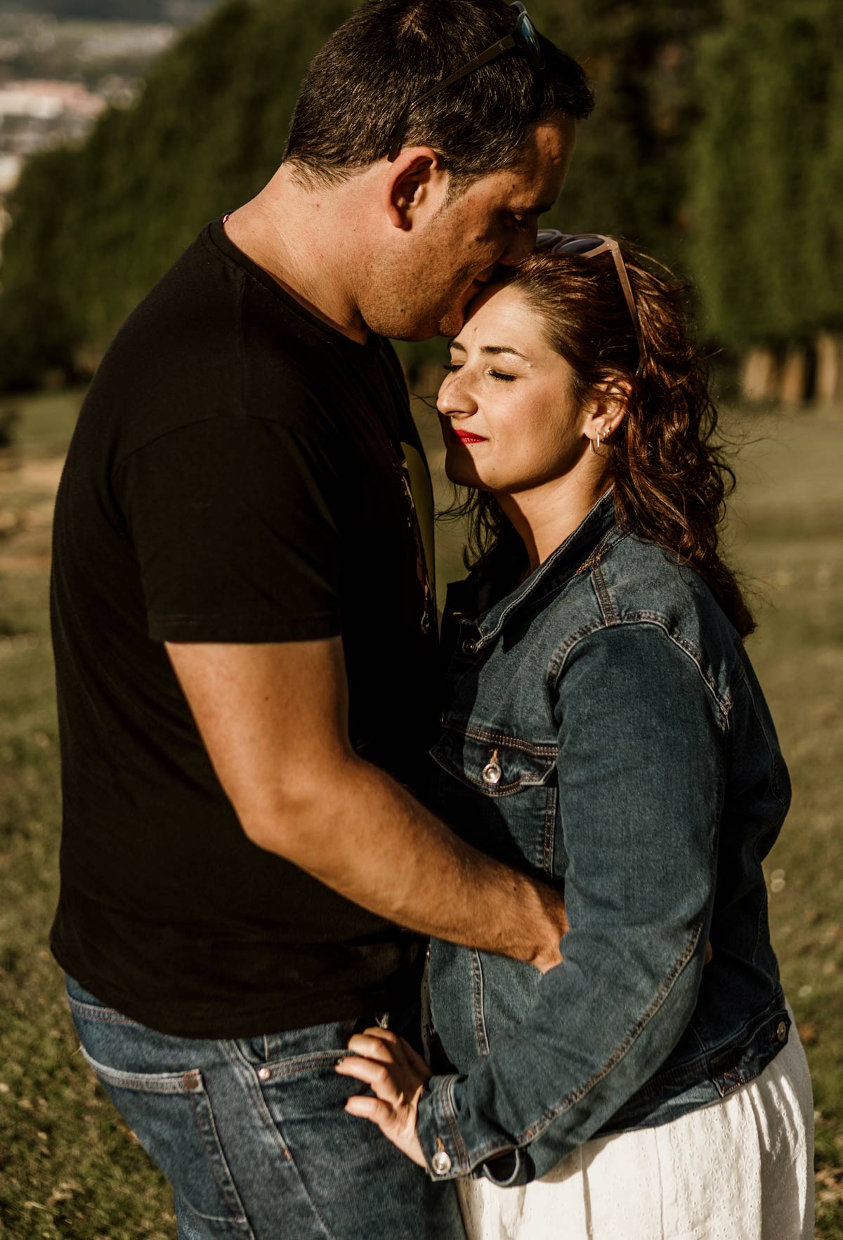Sesión preboda en Bilbao con pareja abrazada al atardecer en un paisaje natural.