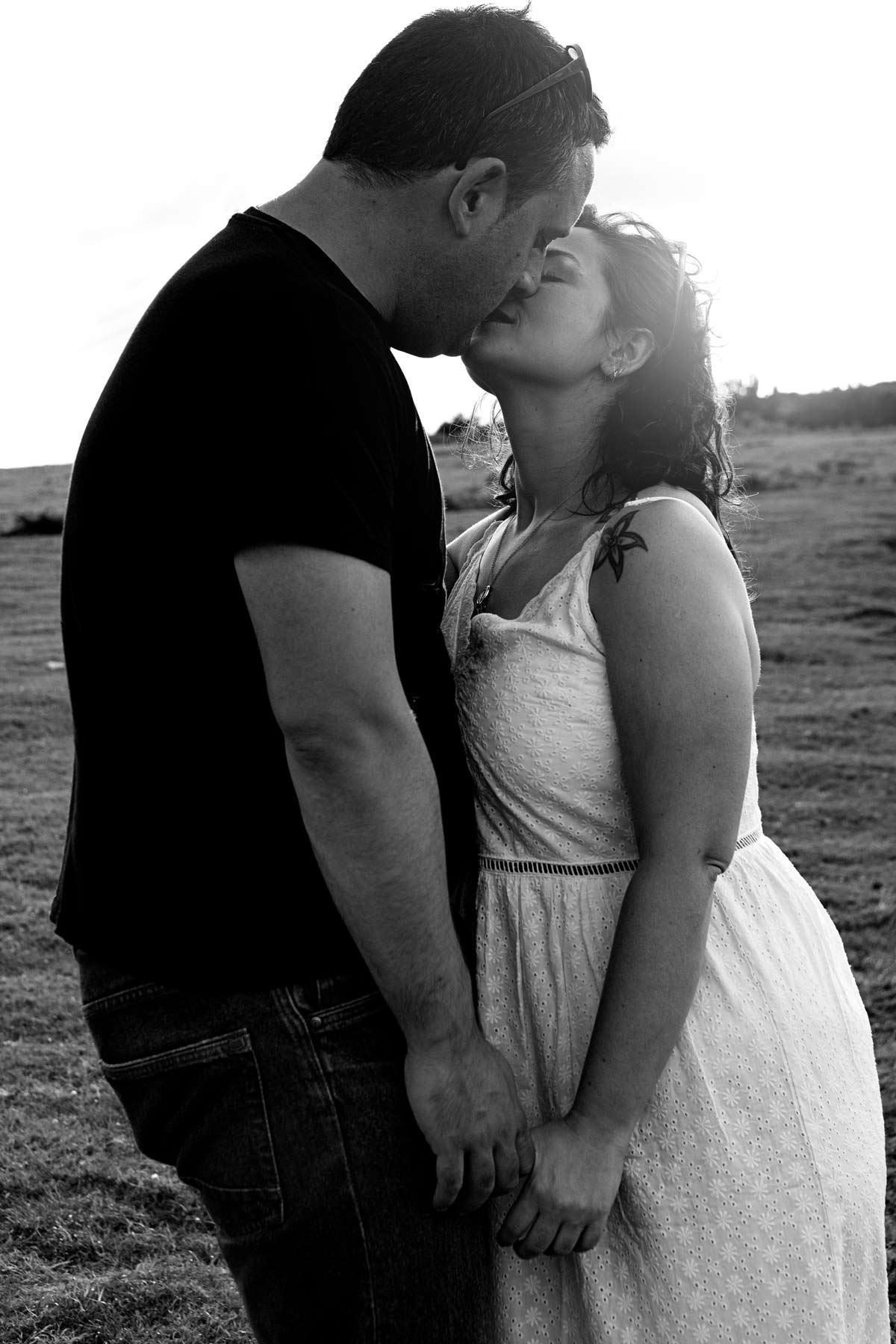 Pareja besándose durante su sesión preboda en un campo cerca de Gijón.
