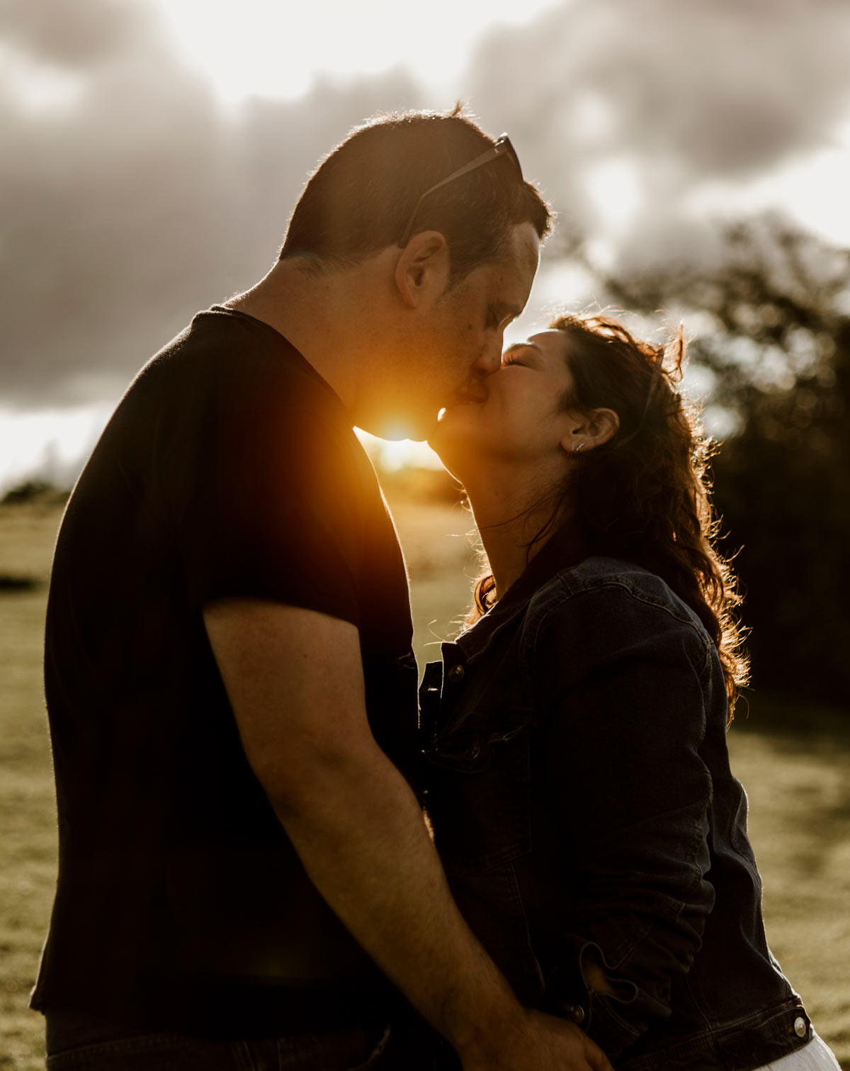 Pareja besándose al atardecer durante una sesión preboda en Oviedo.