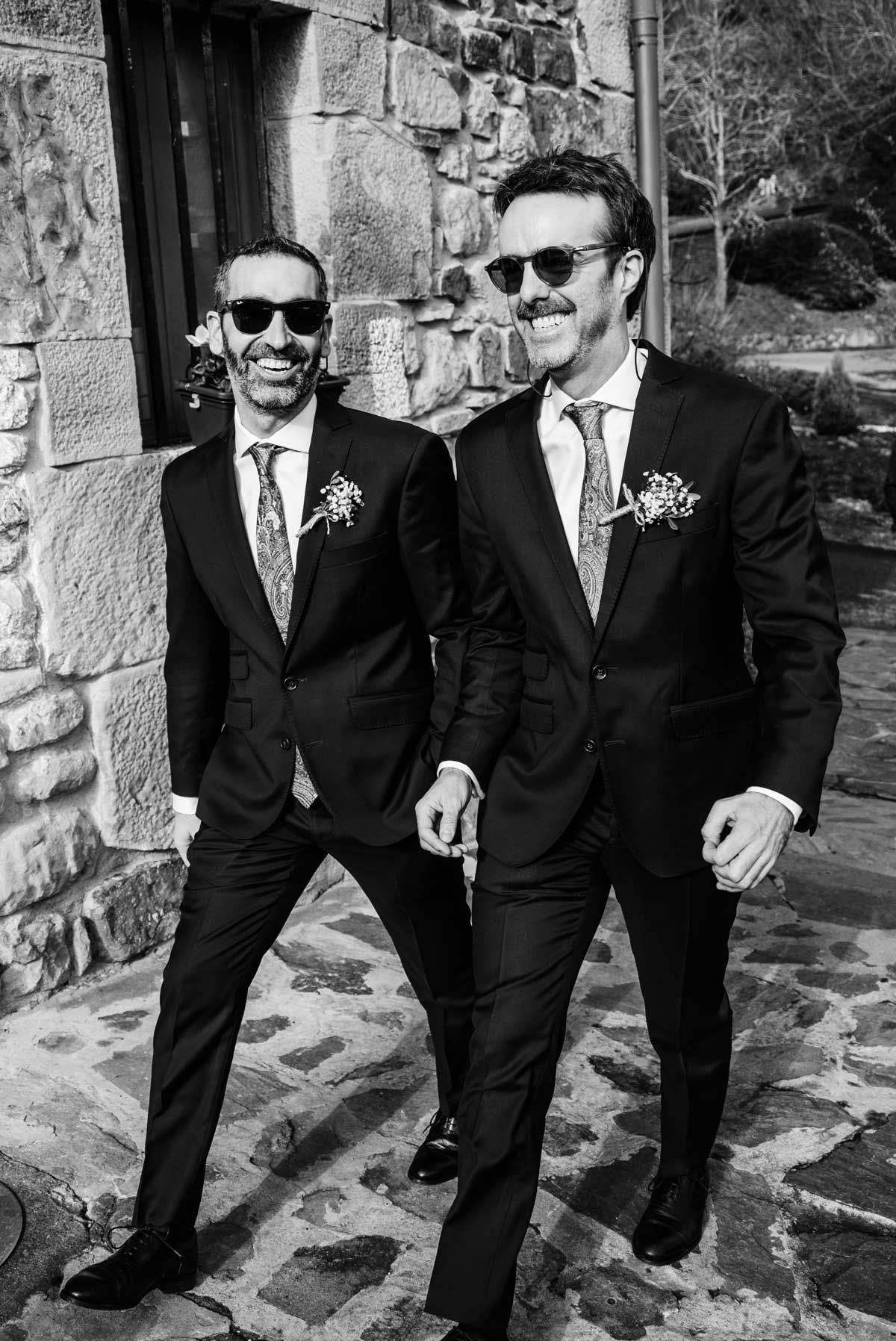 Escena en blanco y negro de dos invitados caminando juntos durante una boda en Bilbao.