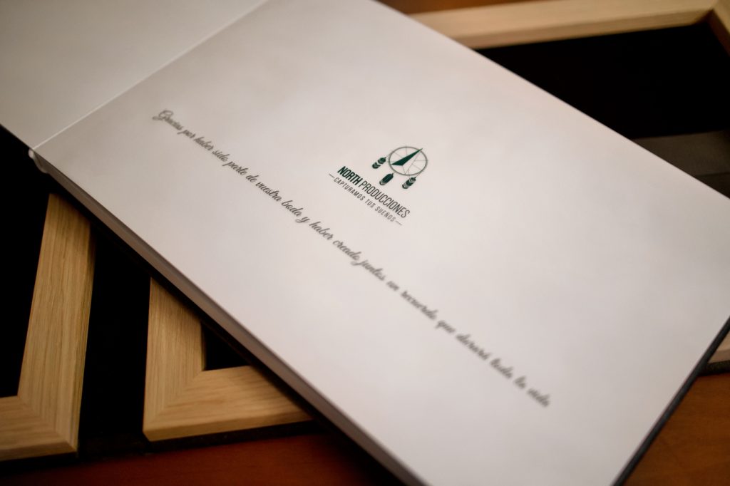 Álbum de boda profesional con acabado elegante sobre mesa de madera.