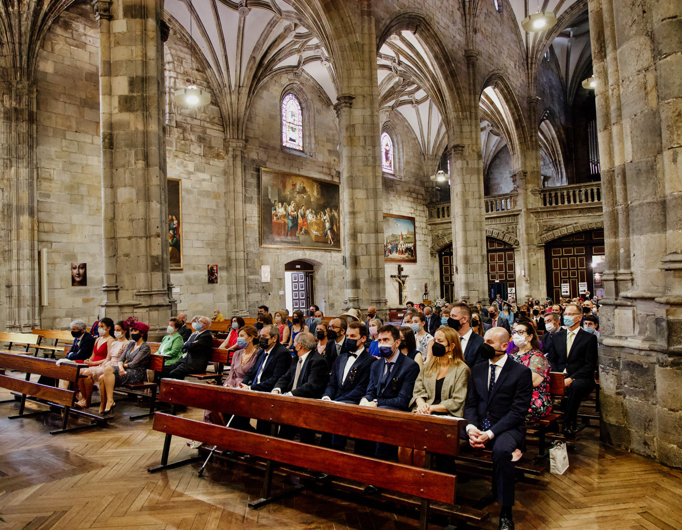 Invitados sentados durante una ceremonia de boda en una iglesia de arquitectura gótica en Bızkala.