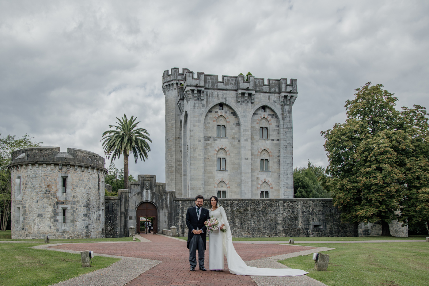 Pareja de boda posando frente al Castillo de Arteaga en Bizkaia durante su reportaje fotográfico.