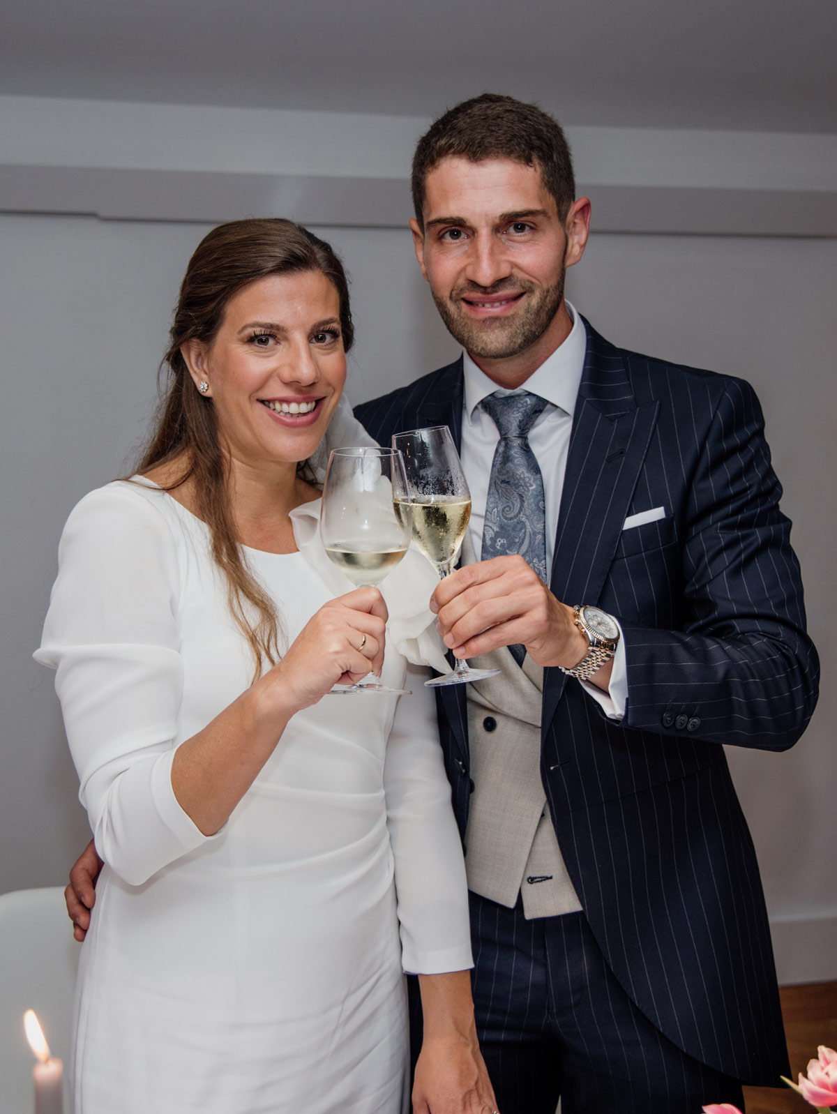 Pareja de recién casados brindando con copas de champan durante la celebración de la boda.
