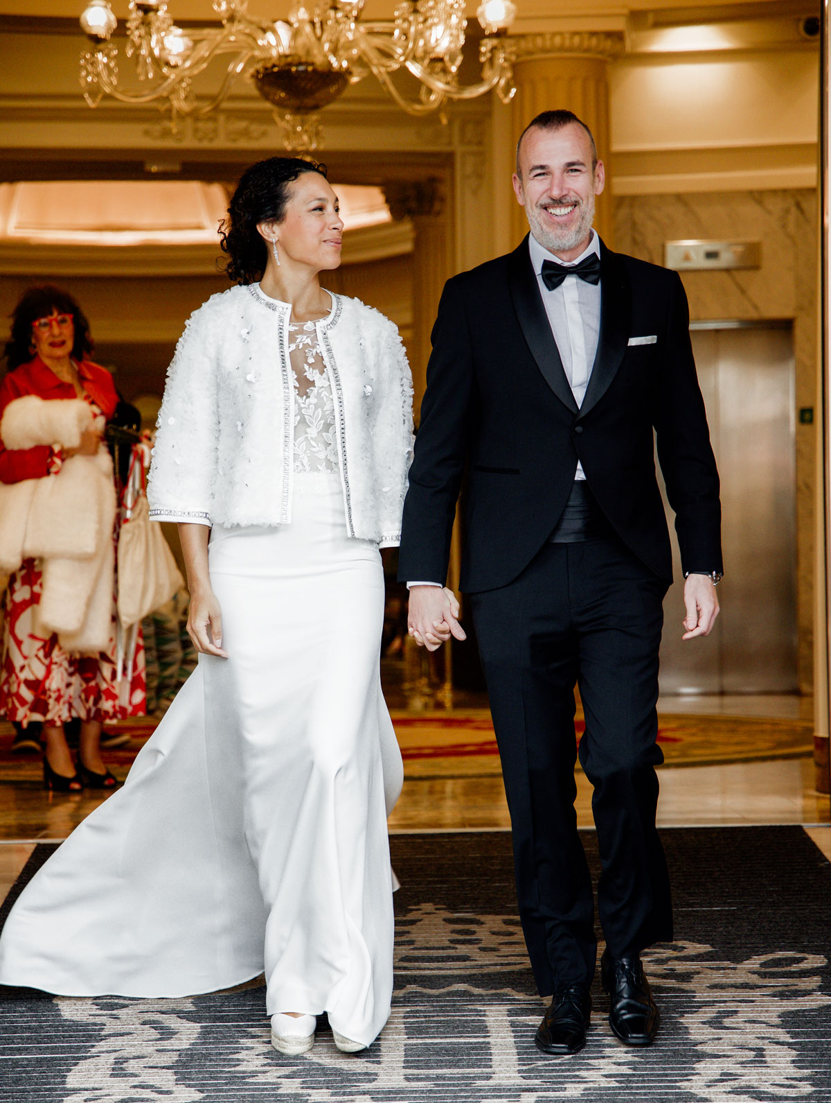 Novios entrando juntos en un salón elegante durante su boda, fotografía realizada por un fotógrafo de bodas en Bilbao.