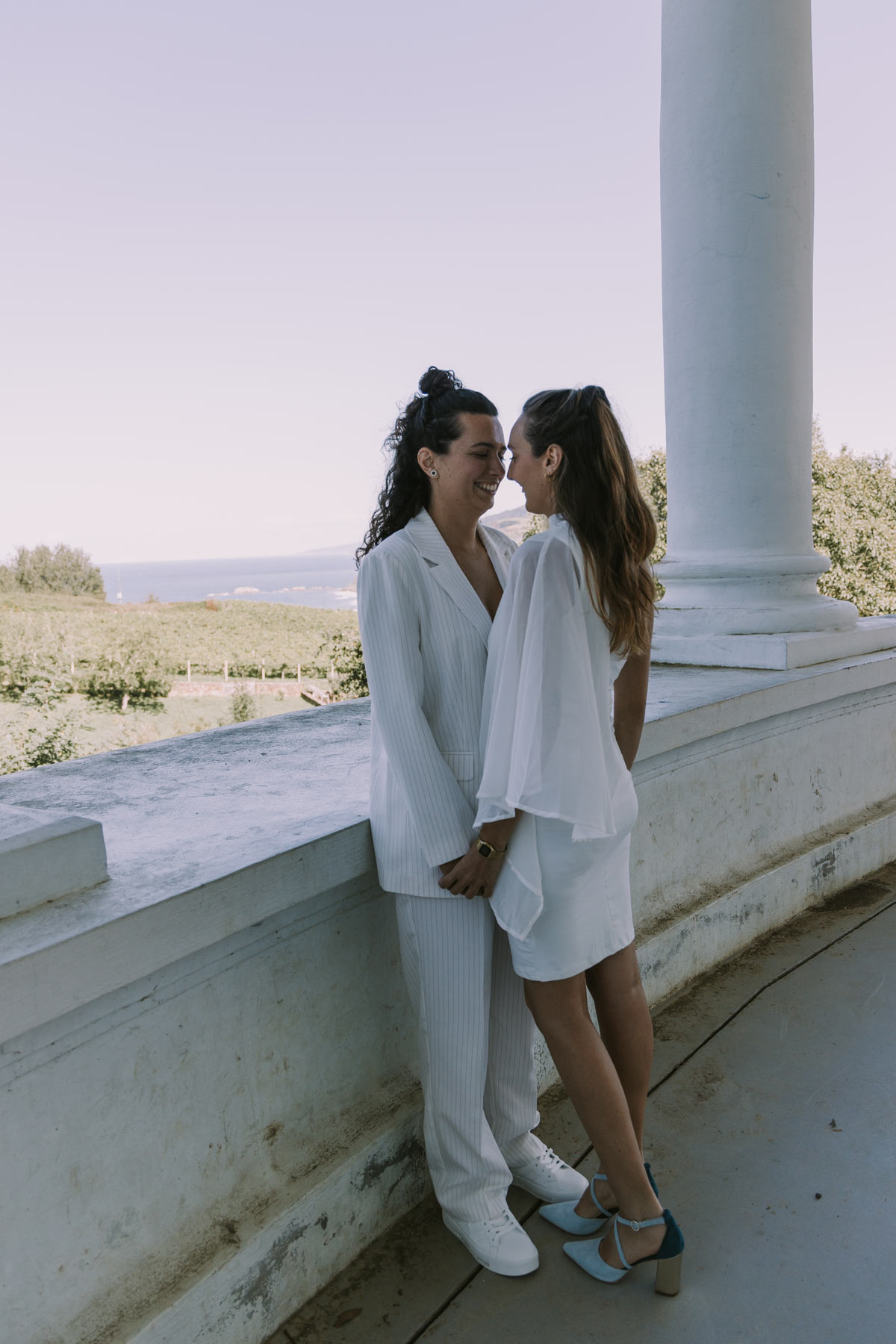 Pareja de novias vestidas de blanco en un momento íntimo durante su sesión de boda, fotografiadas por un fotógrafo de bodas en Bilbao y Bizkaia.