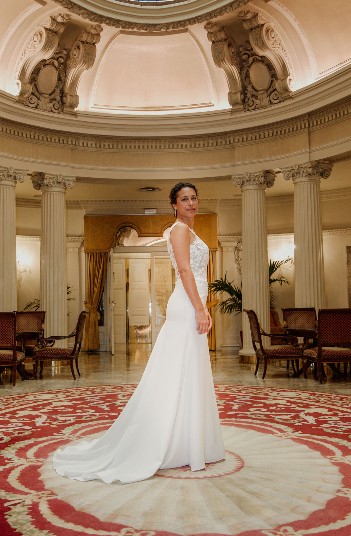 Novia posando en un salón elegante con columnas y decoración clásica, fotografía realizada por un fotógrafo de bodas en San Sebastián.