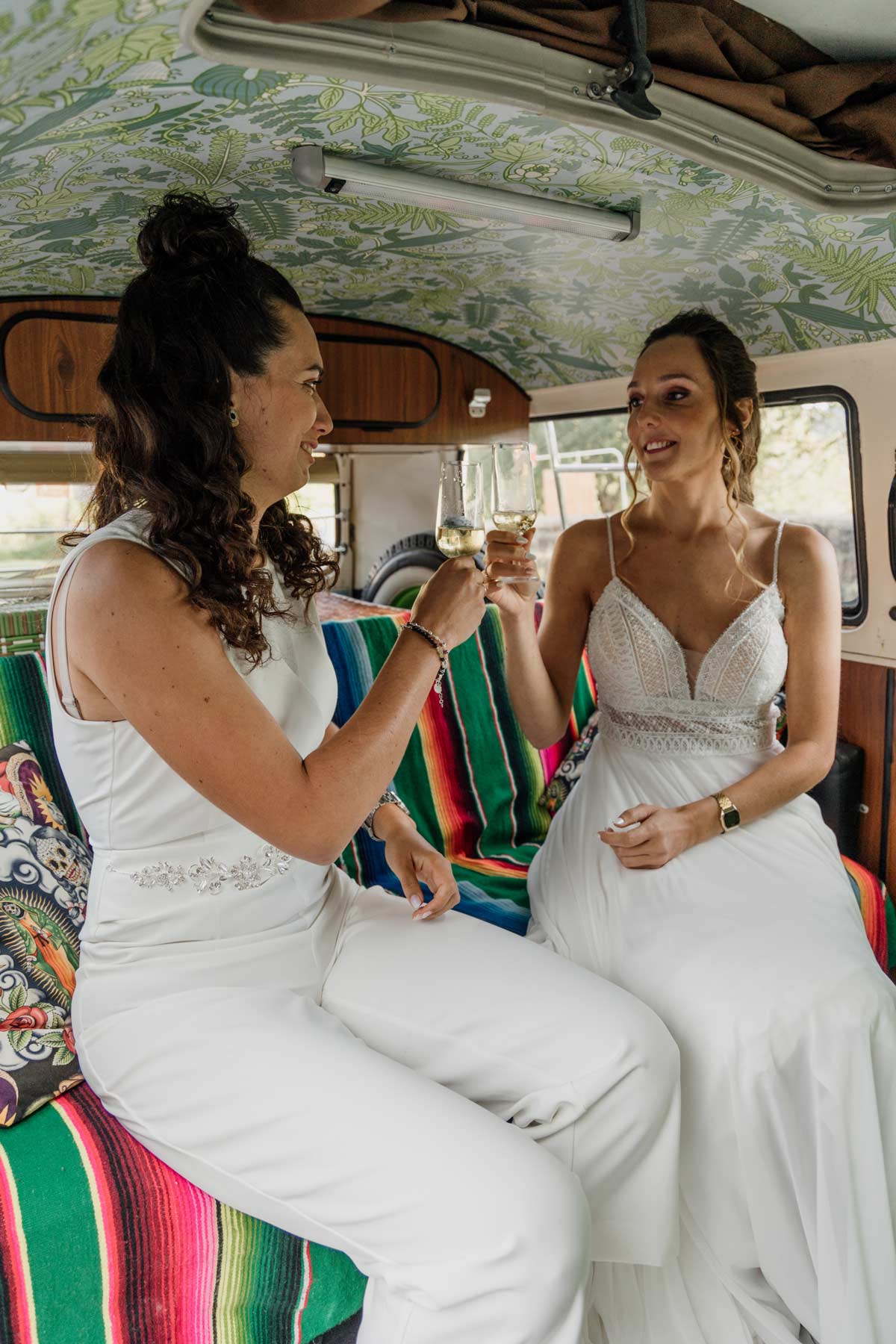 "Dos novias brindando dentro de una furgoneta decorada durante su boda, fotografía de boda en Euskadi."