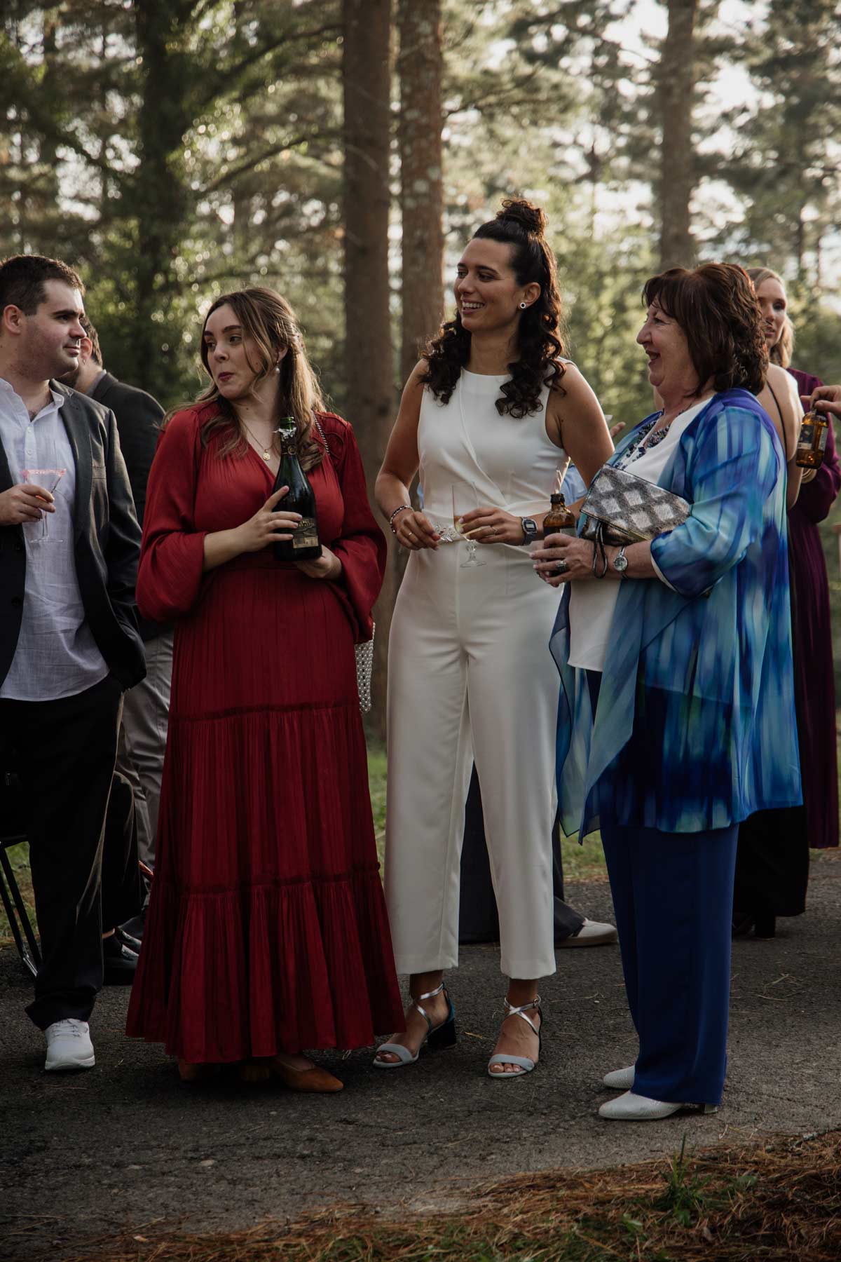 "Invitados conversando al aire libre durante una boda en un entorno de bosque, fotografía de boda en Bizkaia."