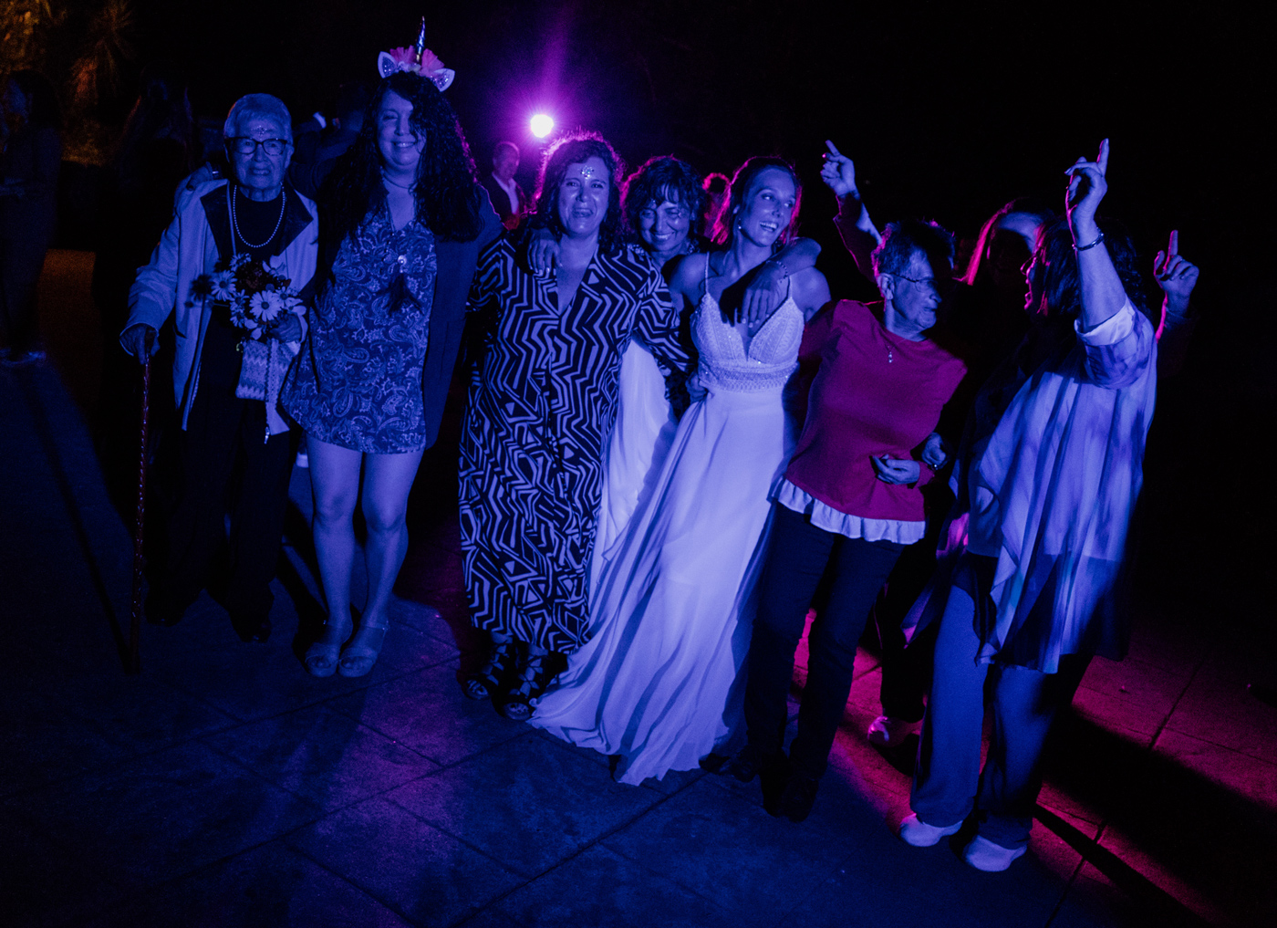 Grupo de invitadas celebrando en una boda con iluminación nocturna, fotografía de reportaje de boda en Bizkaia.