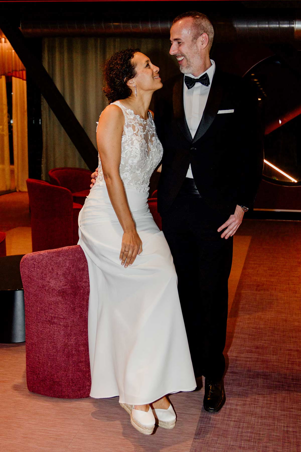 Pareja de boda compartiendo un momento de complicidad en un interior elegante durante un reportaje fotográfico en Bizkaia.