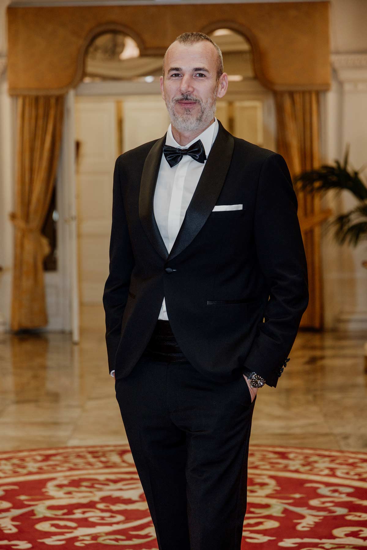 Persona vestida de traje posando en el interior elegante del Hotel Carlton de Bilbao durante un reportaje fotográfico de boda.