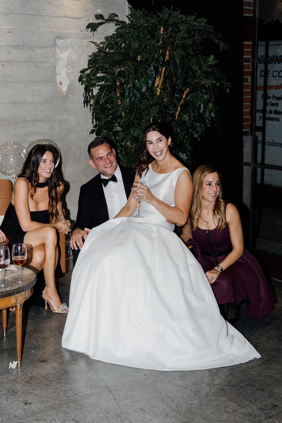 Novia sentada con invitados en un ambiente elegante durante una boda en Bilbao - fotografía natural y espontánea de North Producciones