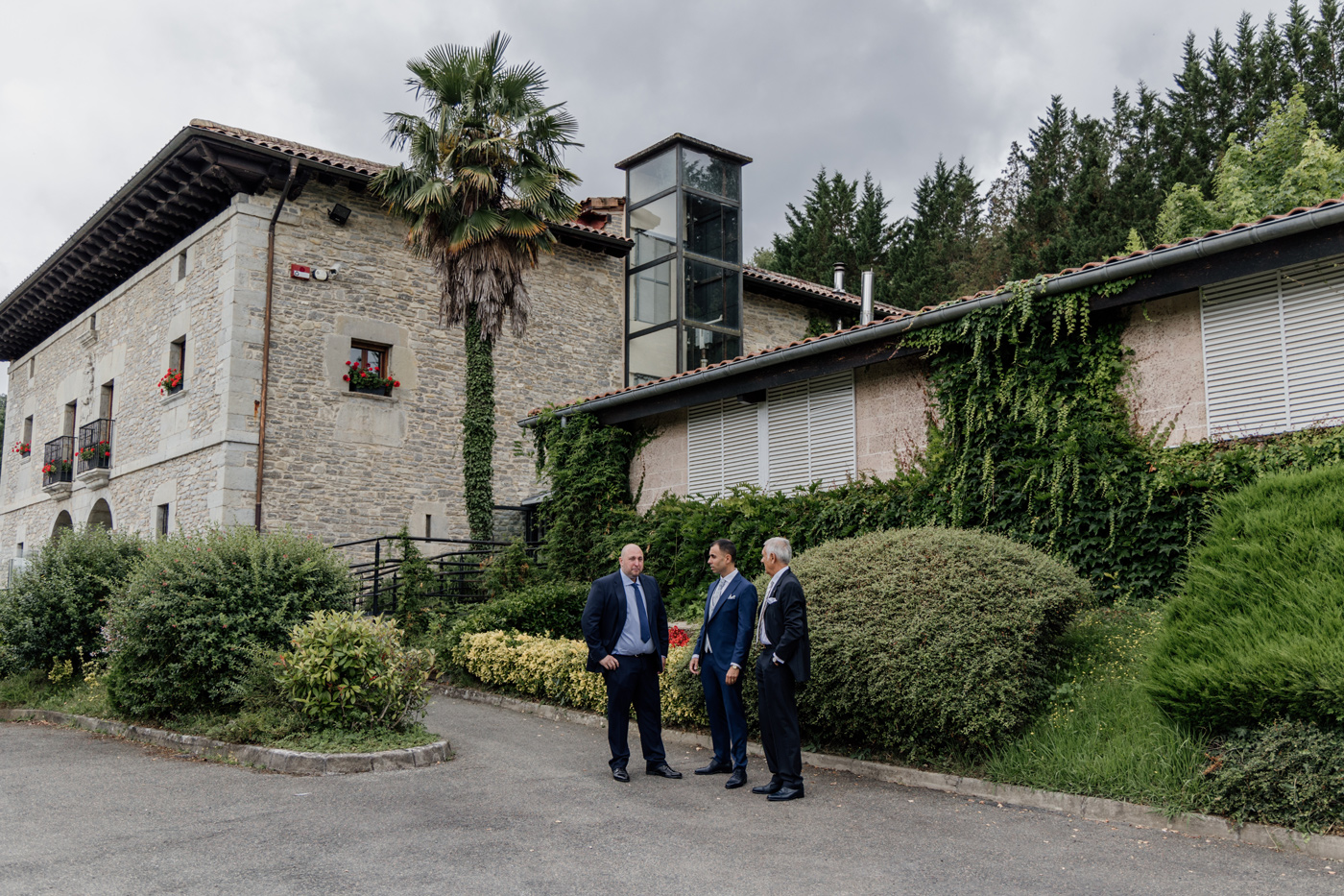 Exterior del caserio Arcos de Quejana en una boda en Bilbao, con invitados conversando antes de la ceremonia.