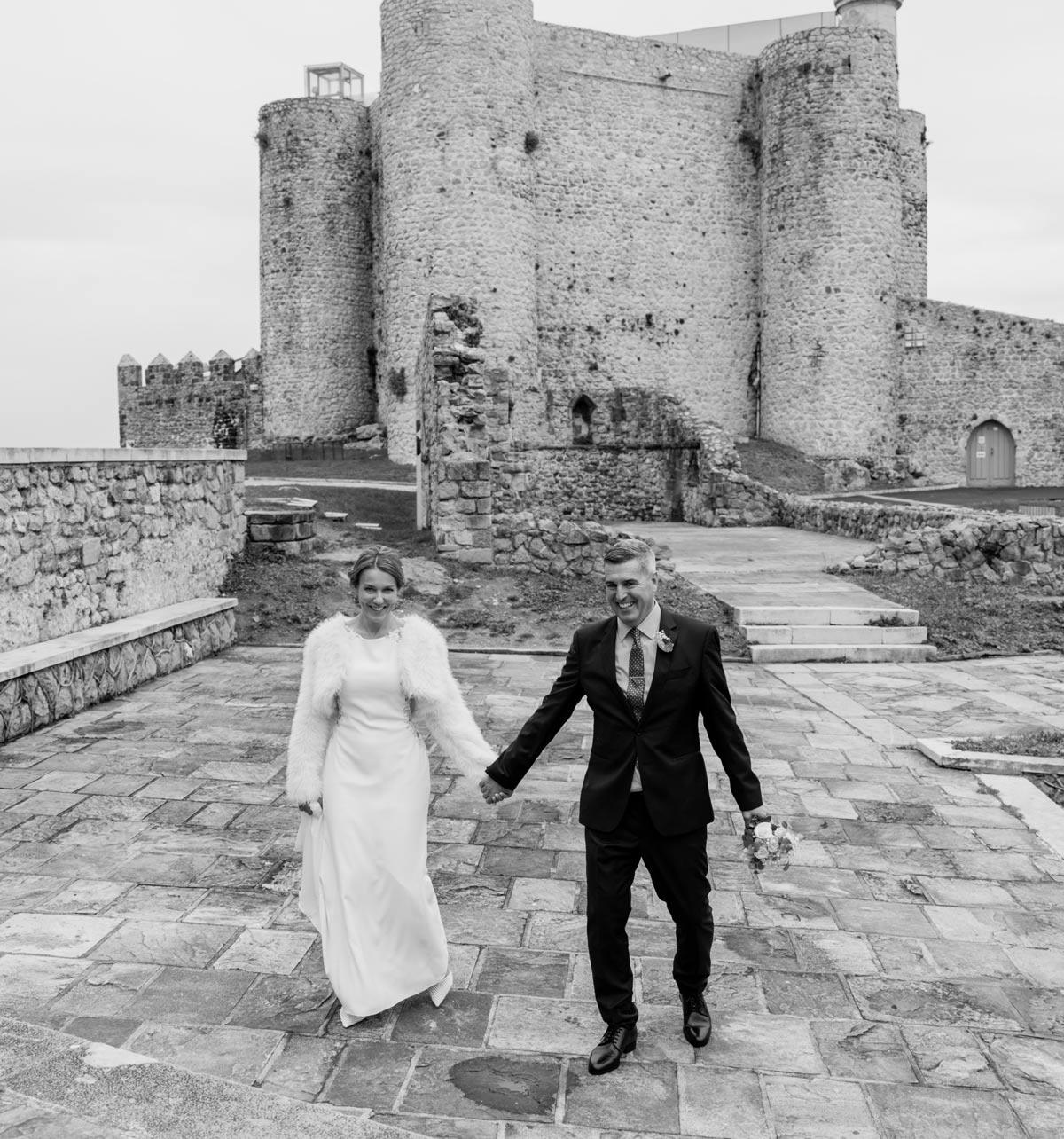 Novia saliendo del coche con su ramo el día de su boda en Bilbao — fotografía emocional en blanco y negro de North Producciones