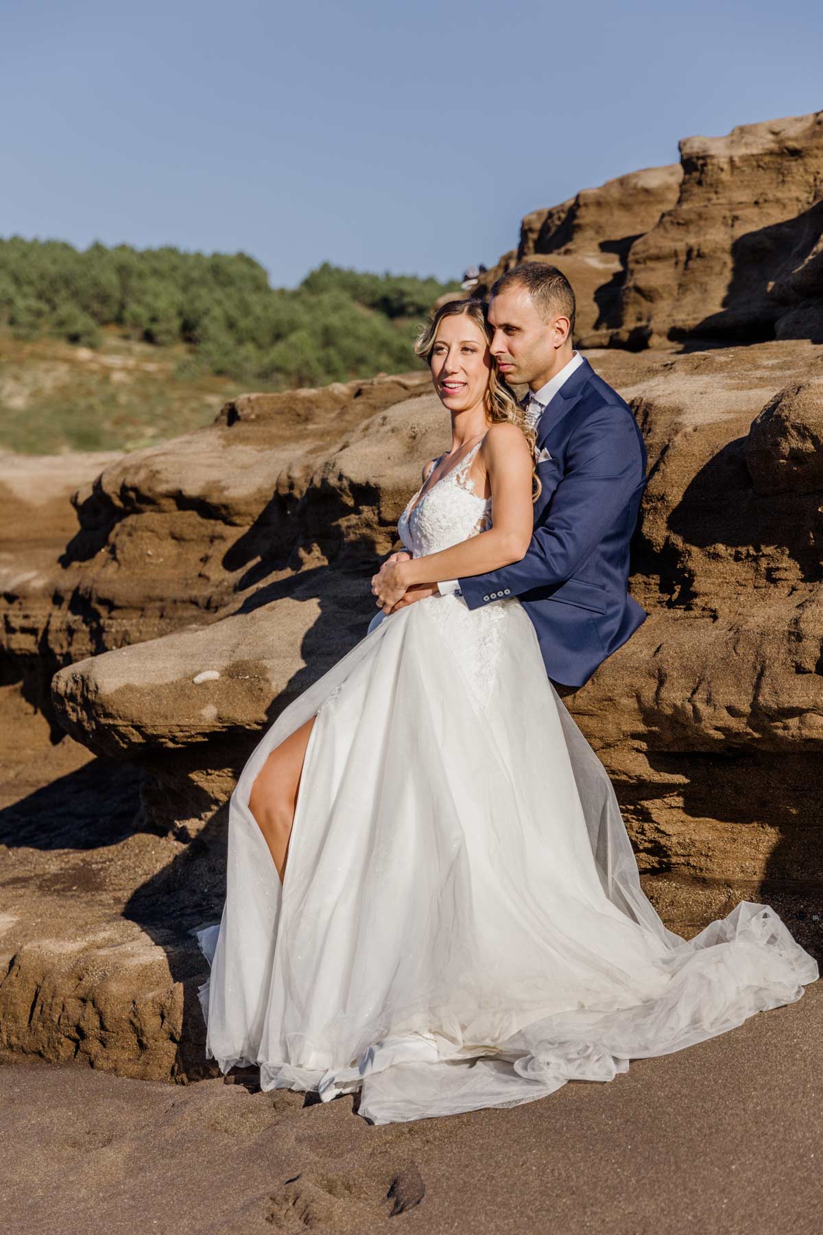 Pareja de novios posando abrazados sobre formaciones rocosas durante su sesión de boda en Bizkaia - Fotógrafo de bodas en Bizkaia у Bilbao