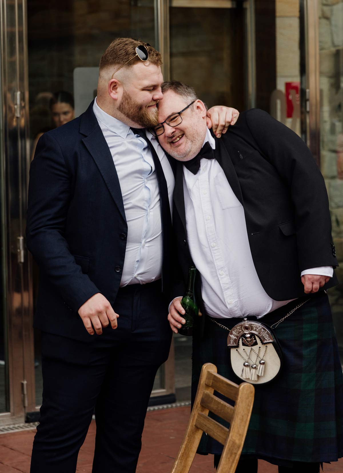 Dos invitados abrazados y riendo en un momento espontáneo durante una boda en Bizkaia, fotografía natural de North Producciones.