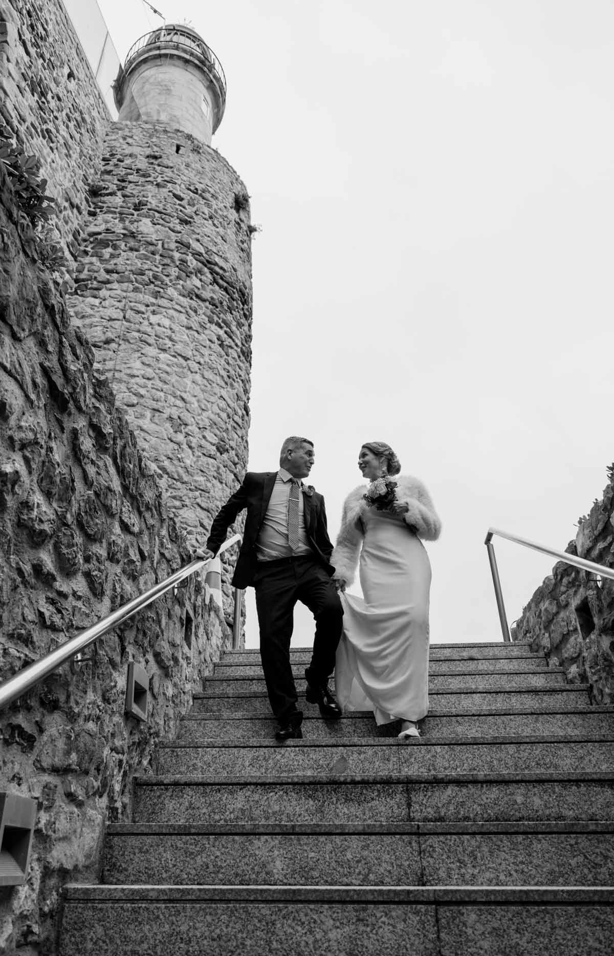 Novia saliendo del coche con su ramo el día de su boda en Bilbao — fotografía emocional en blanco y negro de North Producciones