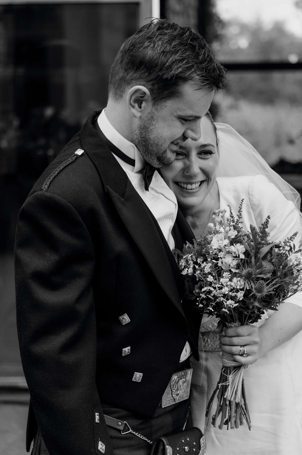 Pareja de recién casados abrazándose con ternura durante su boda, fotografía emocional en blanco y negro realizada por un fotógrafo de bodas en Bizkaia.