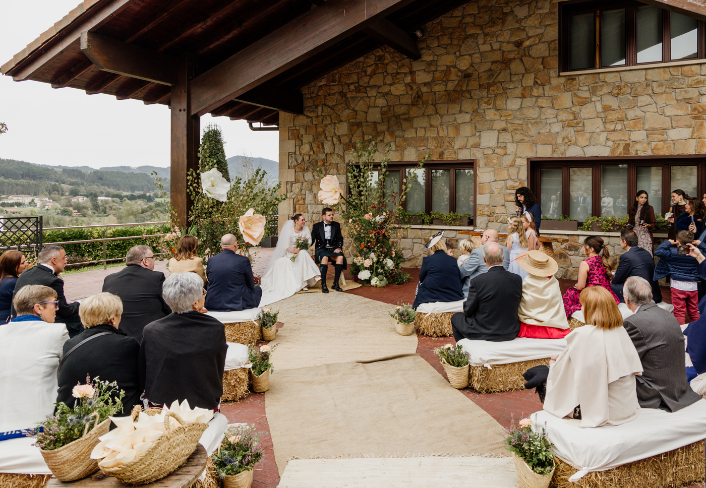Ceremonia de boda al aire libre en un caserío con vistas a las montañas, fotografía documental realizada por un fotógrafo de bodas en Bizkaia.
