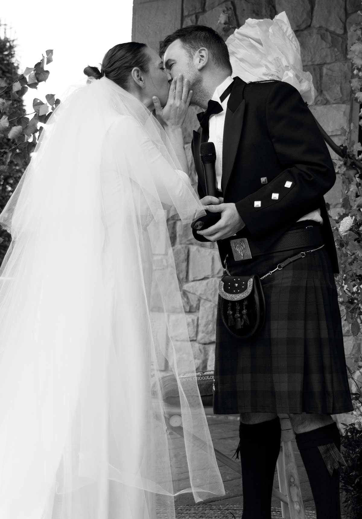 Pareja de recién casados compartiendo un beso durante la ceremonia, fotografía en blanco y negro capturada por un fotógrafo de bodas en Bizkaia.