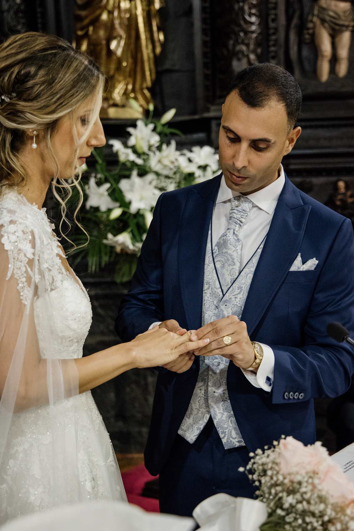 Novio colocando el anillo a la novia durante la ceremonia de boda en una iglesia, fotografía de boda en Bilbao.