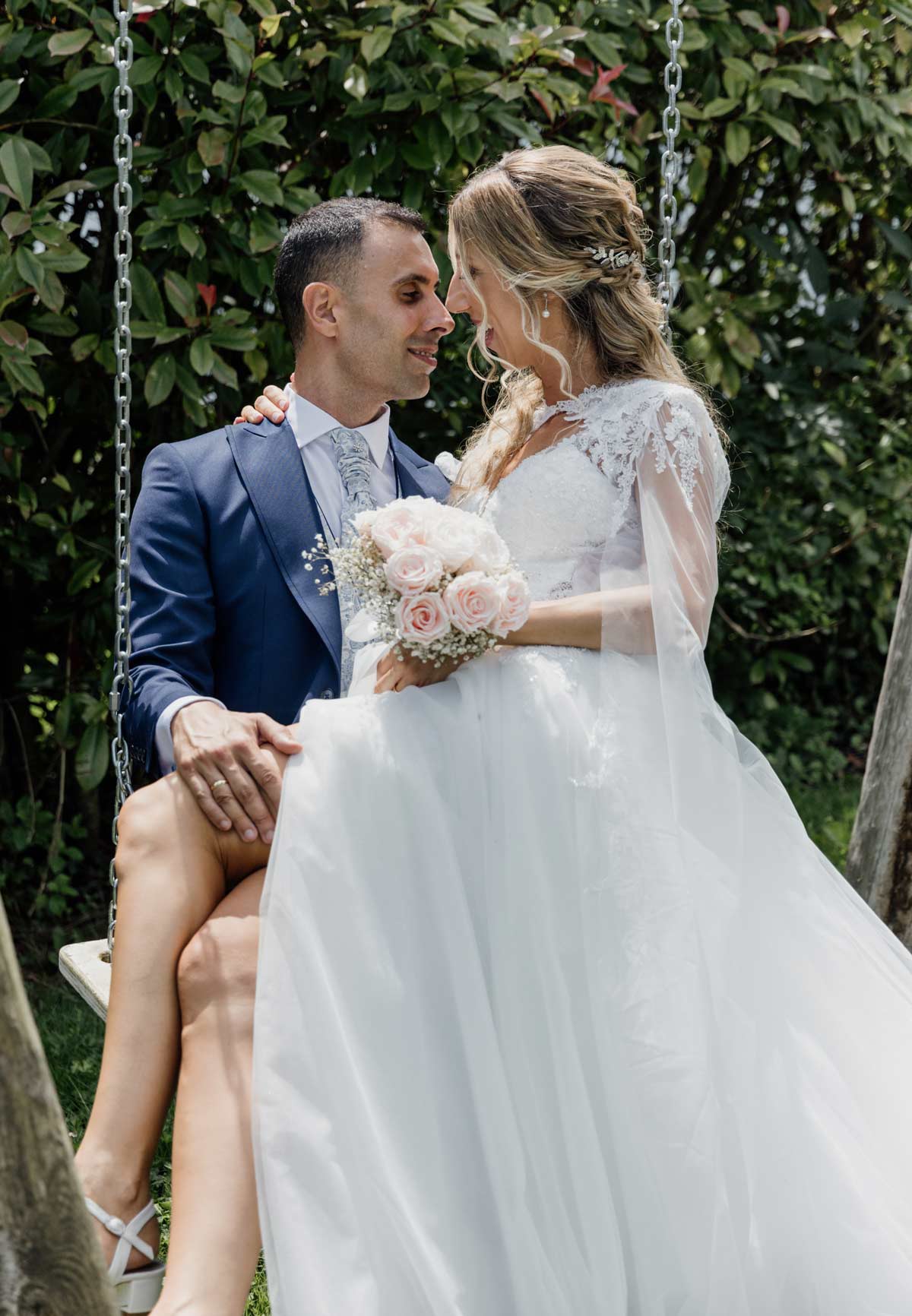 Pareja de recién casados sentados en un columpio al aire libre durante su sesión de boda, fotografiada por un fotógrafo de bodas en Bilbao.