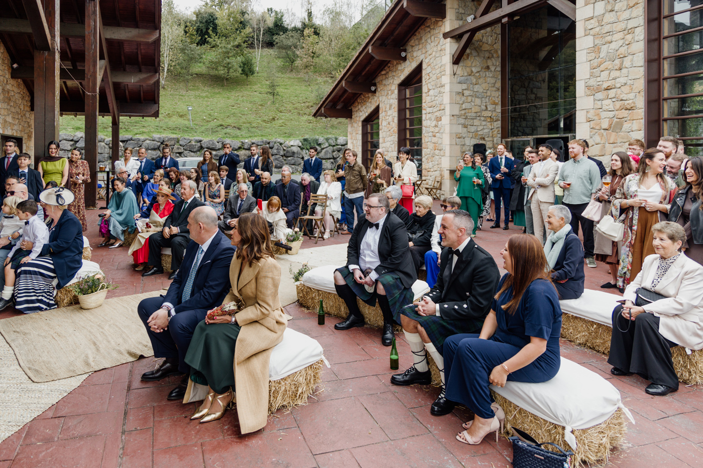 Invitados esperando el inicio de una boda al aire libre en un caserío, fotografía documental realizada por un fotógrafo de bodas en Bizkaia.
