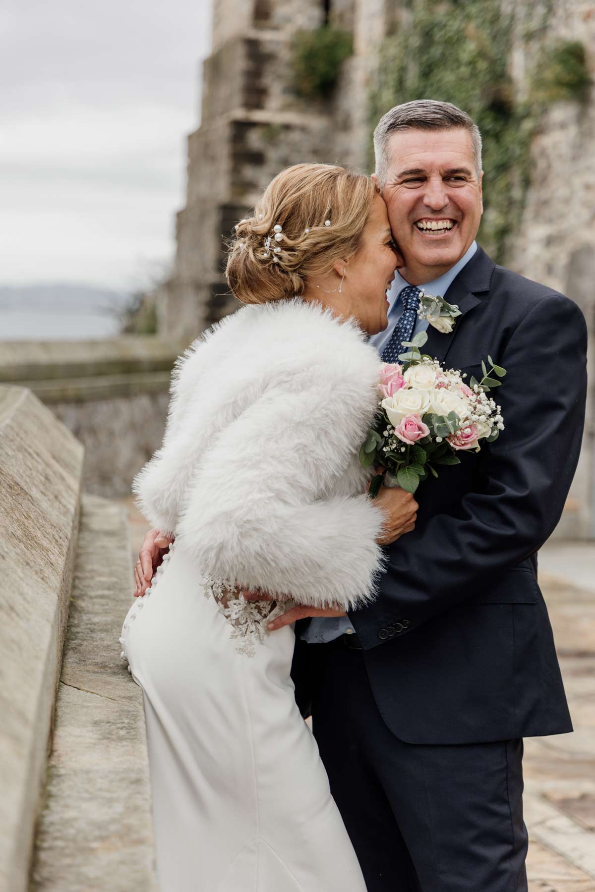 Pareja de recién casados abrazándosela y sonriendo durante su boda en Cantabria