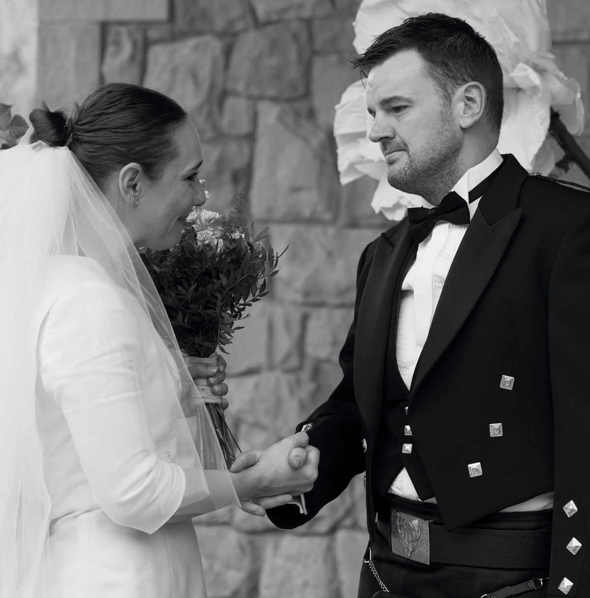 Pareja de recién casados tomándose de las manos y mirándose con emoción, fotografía en blanco y negro realizada por un fotógrafo de bodas en Bizkaia.