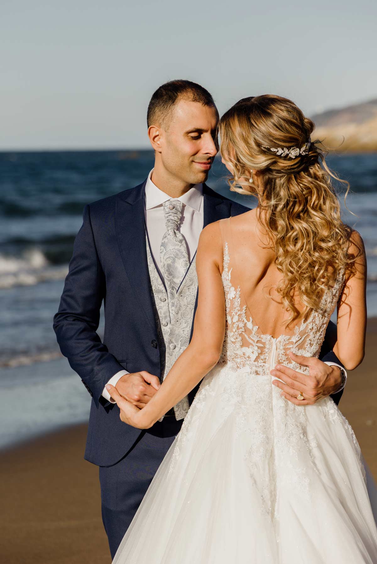 Novios abrazados y mirándose en la playa durante su postboda - Fotógrafo de bodas en Bilbao y Bizkaia.