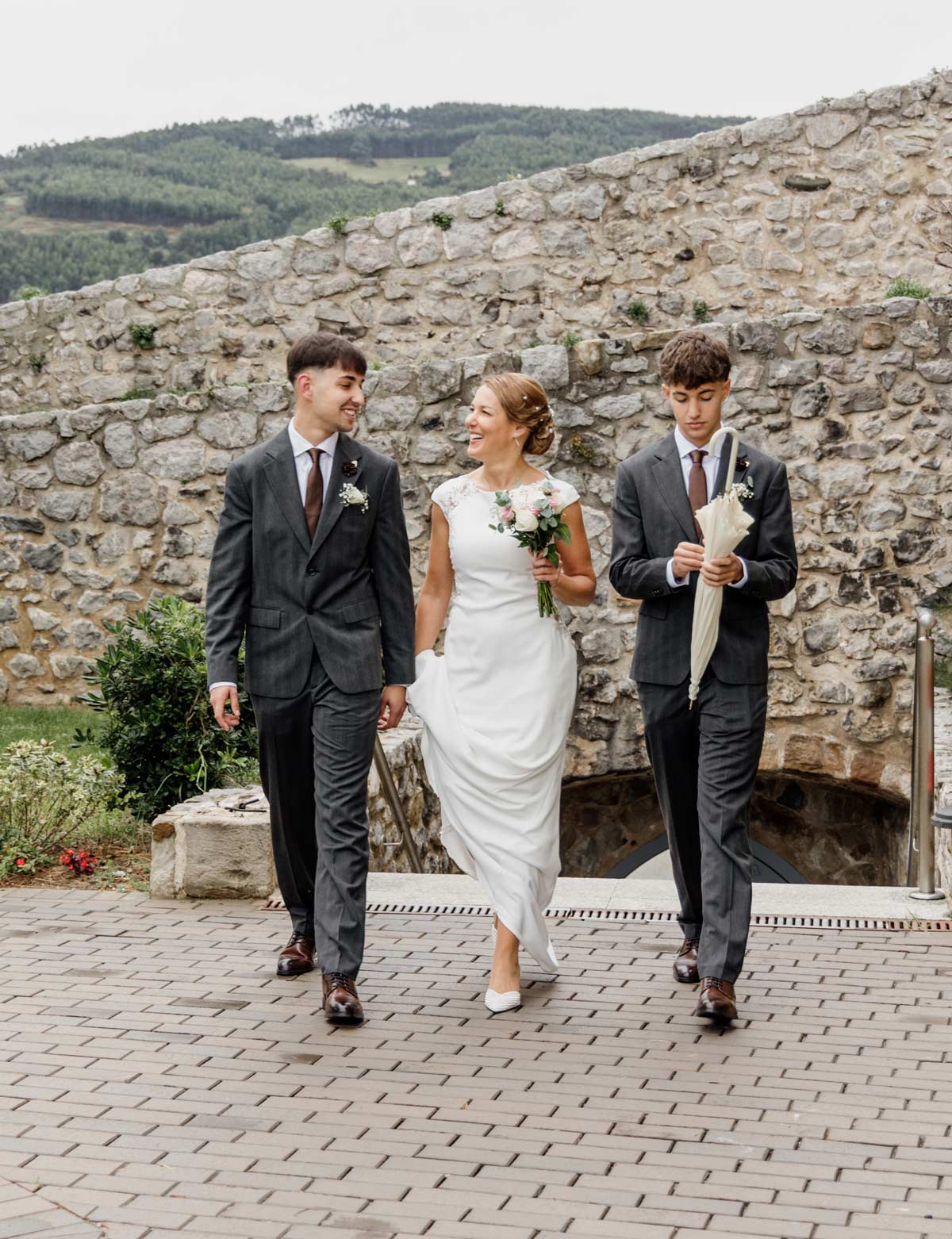 Novia caminando con dos acompañantes durante su boda en Cantabria