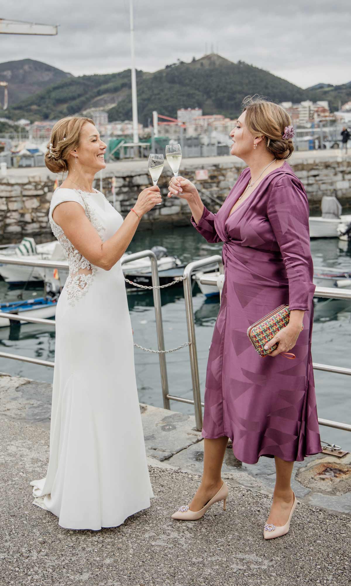 Novia brindando con una invitada durante su boda en la costa de Cantabria