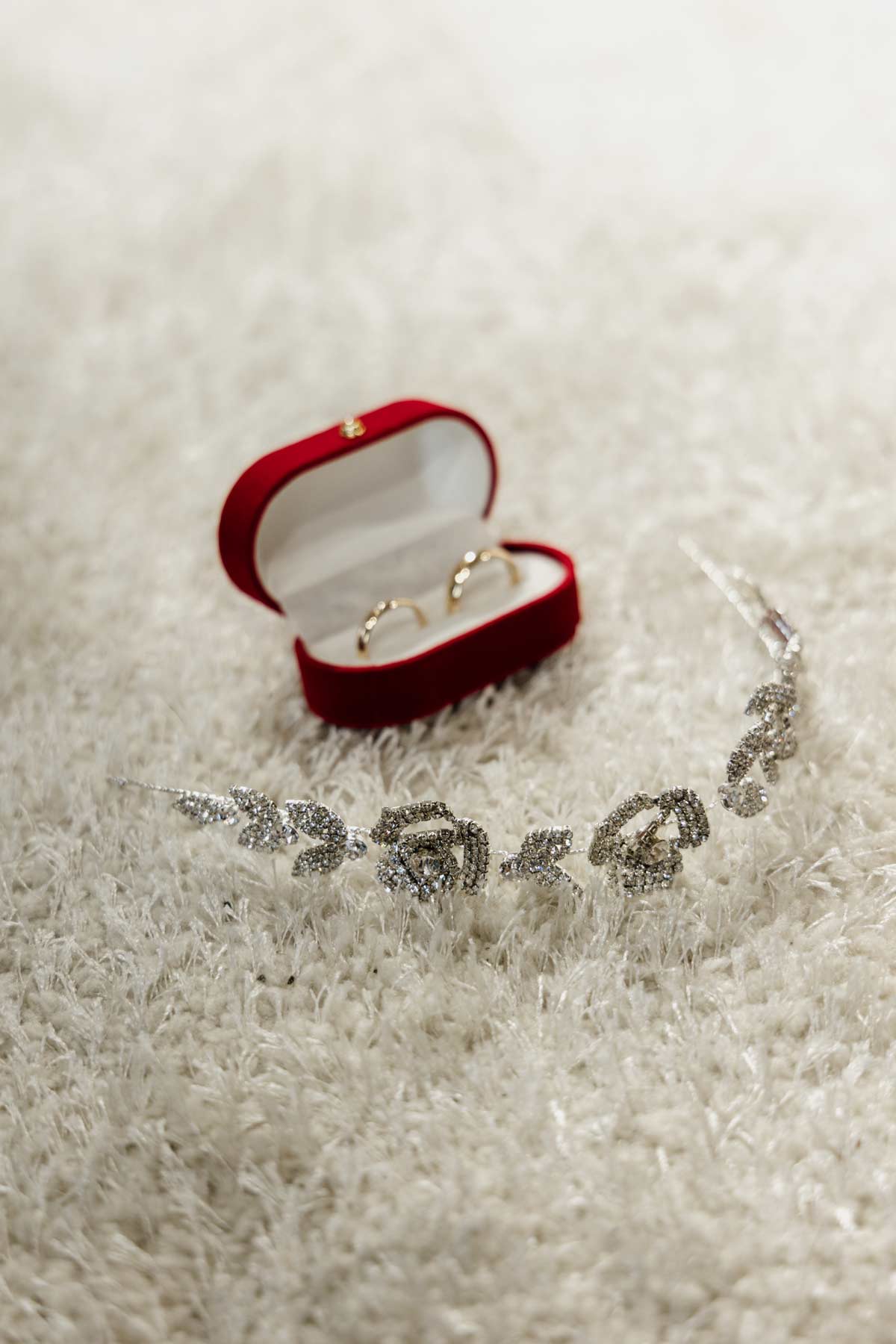 Detalles de joyería de boda con anillos en un estuche rojo, fotografiados por un fotógrafo de bodas en Bilbao.
