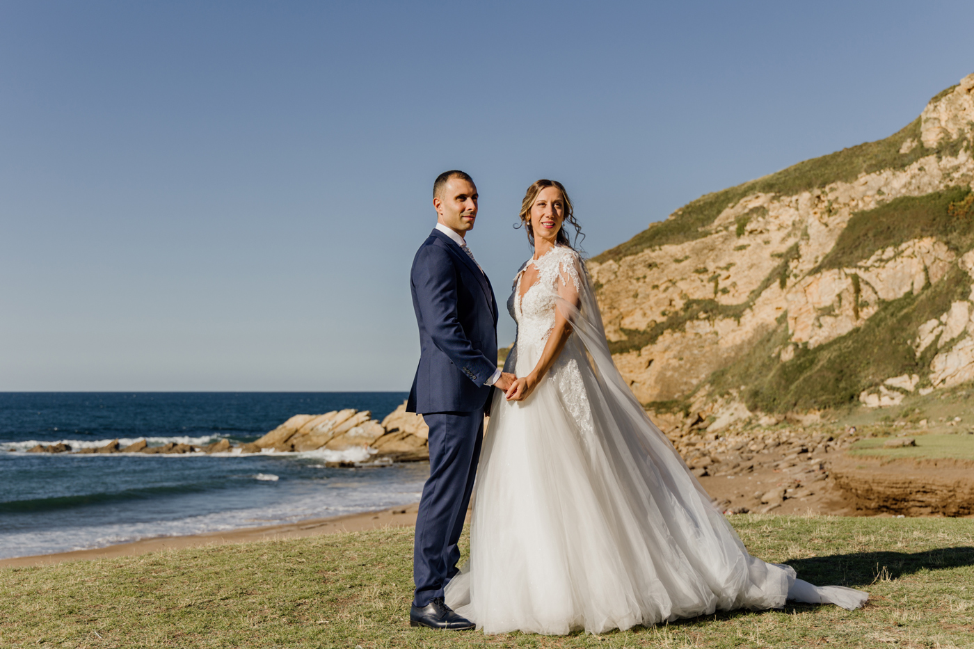 Pareja de novios posando frente al mar durante su boda — Fotógrafo de bodas en Bilbao y Bizkaia.