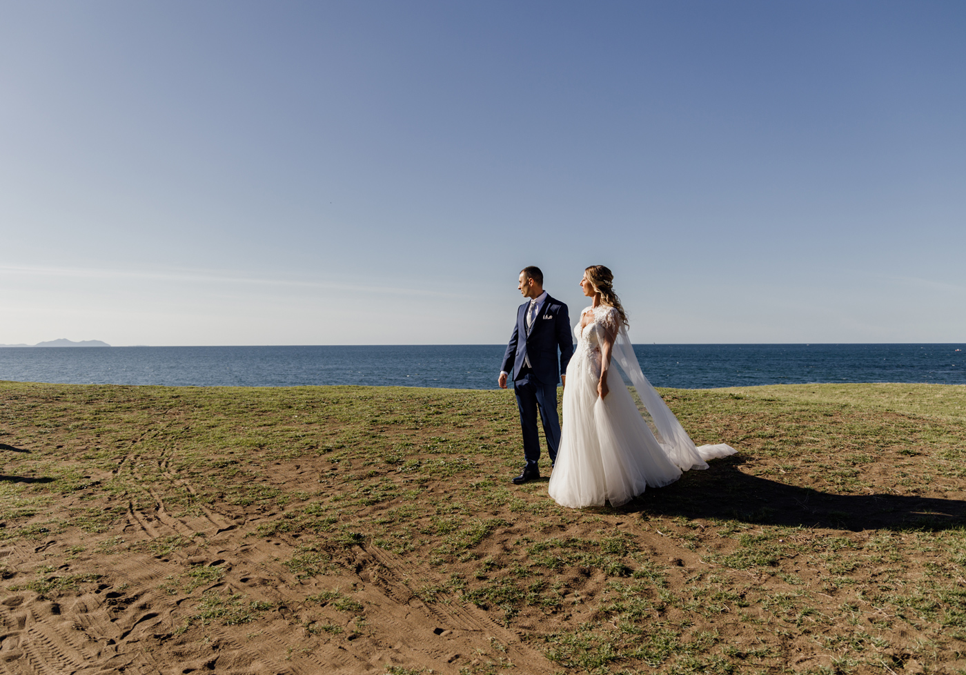 Pareja de novios posando frente al mar durante su boda-Fotógrafo de bodas en Bizkaia.