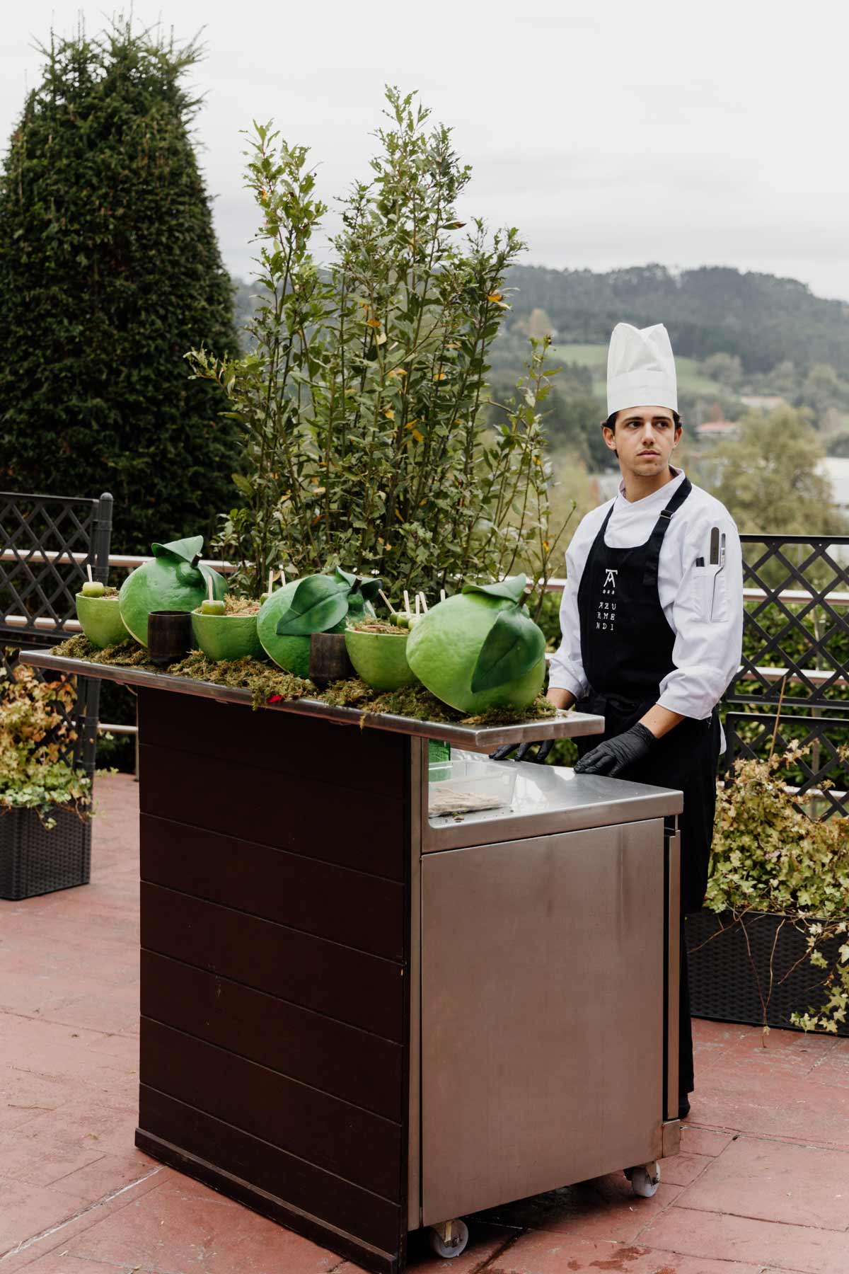 Cocinero atendiendo un puesto gastronómico al aire libre durante una boda en Bizkaia